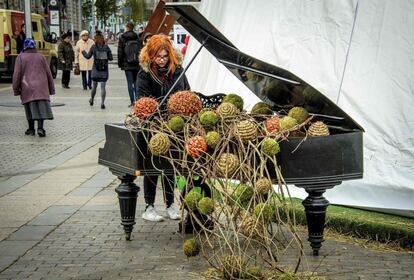 Una mujer intenta tocar un piano decorado con motivos otoñales en Moscú, Rusia.