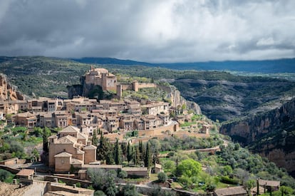 Alquézar (Huesca). Alquézar era ‘al-Qasr’, el alcázar, un castillo moro con un foso de más de 300 metros de profundidad: el cañón del río Vero. Ahora este es uno de los pueblos más bonitos y escarpados de España; su castillo, una colegiata amurallada con un precioso claustro románico, el único de Aragón que se conserva enteramente pintado; y el cañón, un no parar de senderistas que lo recorren caminando por pasarelas metálicas fijadas a sus paredes verticales y de barranquistas que descienden con un neopreno por los toboganes, pasillos, badinas y piscinas que el Vero ha labrado en las calizas de la sierra de Guara. Dice la leyenda que aún se oyen en el cañón los alaridos de los soldados musulmanes que perdieron Alquézar. No: son los gritos de alegría de estos otros.