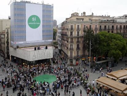 Una gran pancarta y un abanico verde en el suelo en la protesta de los arquitectos