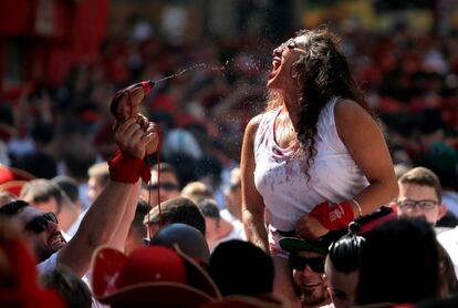 Una joven bebe de una bota de vino, durante el chupinazo de San Fermín 2019.