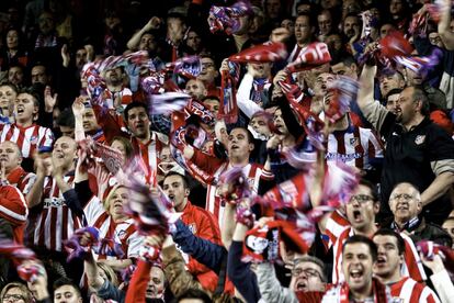 Los hinchas atléticos muestran su alegría tras el final del partido.