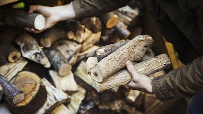 Un hombre apilando trozos de madera.