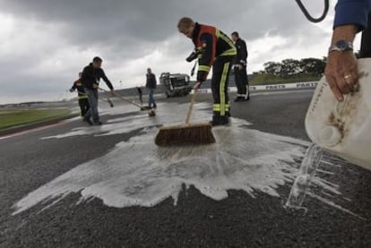 Trabajadores limpian el aceite del circuito.