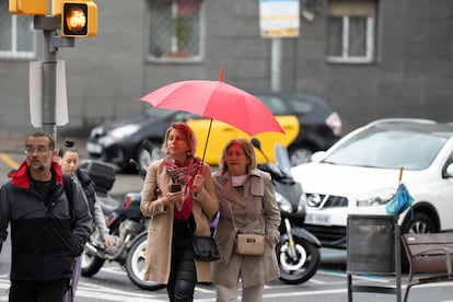 Varias personas con paraguas pasean por Barcelona este viernes.