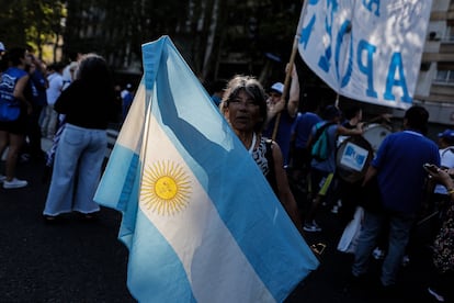 Una mujer sostiene una bandera argentina durante la protesta en la que se unieron docentes, universitarios, sindicatos y miembros de organizaciones sociales.
