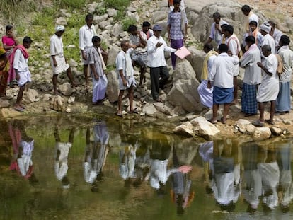Un grupo de trabajadores rurales junto a un embalse en India.