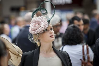 Una joven luce un elegante tocado en el hipódromo.