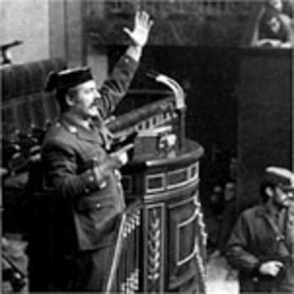 El teniente coronel Tejero, conspirador de la 'operación Galaxia', al mando de un grupo de rebeldes, ocupa el palacio del Congreso de los Diputados, y desde el atril de los oradores conmina a los parlamentarios, pistola en mano, mientras que otros guardias civiles les encañonan con sus fusiles automáticos y les obligan a tenderse en el suelo bajo sus escaños