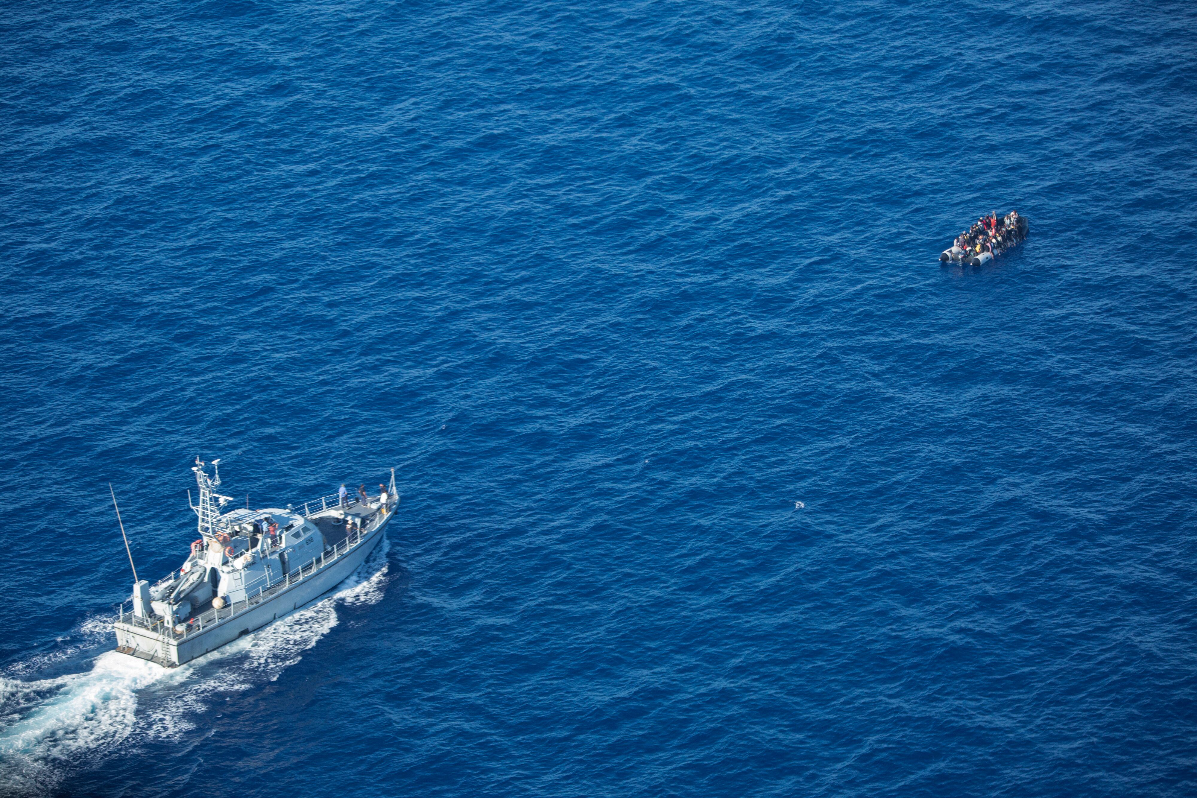 Migrantes que intentan cruzar el mar Mediterráneo en un bote de goma hacia Europa son interceptados por un barco de la guardia costera libia, el 25 de octubre de 2022.