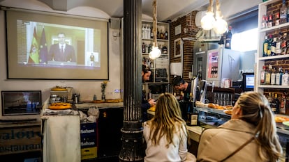 Clientes siguen la comparecencia de Pedro Sánchez en un bar de Madrid.