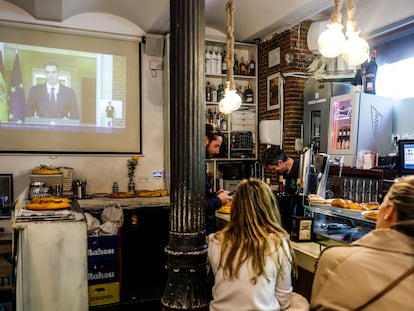 Clientes siguen la comparecencia de Pedro Sánchez en un bar de Madrid.