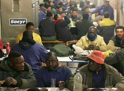 Algunos de los trabajadores de la torre Sacyr almuerzan en el comedor improvisado en el sótano del edificio.