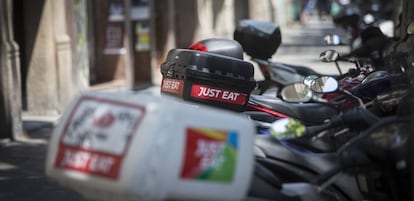 Motos de repartidores de Just eat en una acera de Barcelona. 