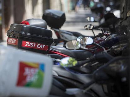Motos de repartidores de Just eat en una acera de Barcelona. 