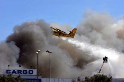 Un avión y un retén de bomberos tratan de aplacar el incendio en el aeropuerto de Estambul.