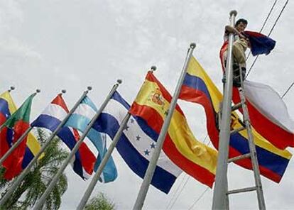 Un trabajador coloca la bandera de uno de los países participantes en la XIII Cumbre Iberoamericana.