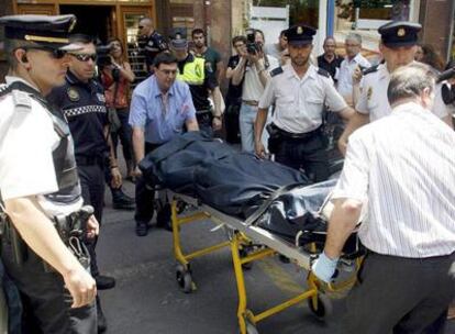 Miembros del retén funerario retiran el cadáver de un hombre tiroteado después de una discusión.