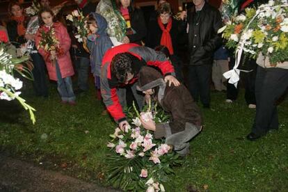 Los padres de los niños fallecidos colocan un ramo de flores en el lugar donde se produjo el accidente.
