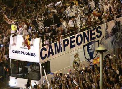 El autobús con los jugadores del Real Madrid se abre paso hasta Cibeles anoche entre decenas de miles de seguidores.