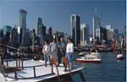 Un grupo de turistas se fotografía en Hong Kong con el perfil arquitectónico de la ciudad como espectacular fondo.