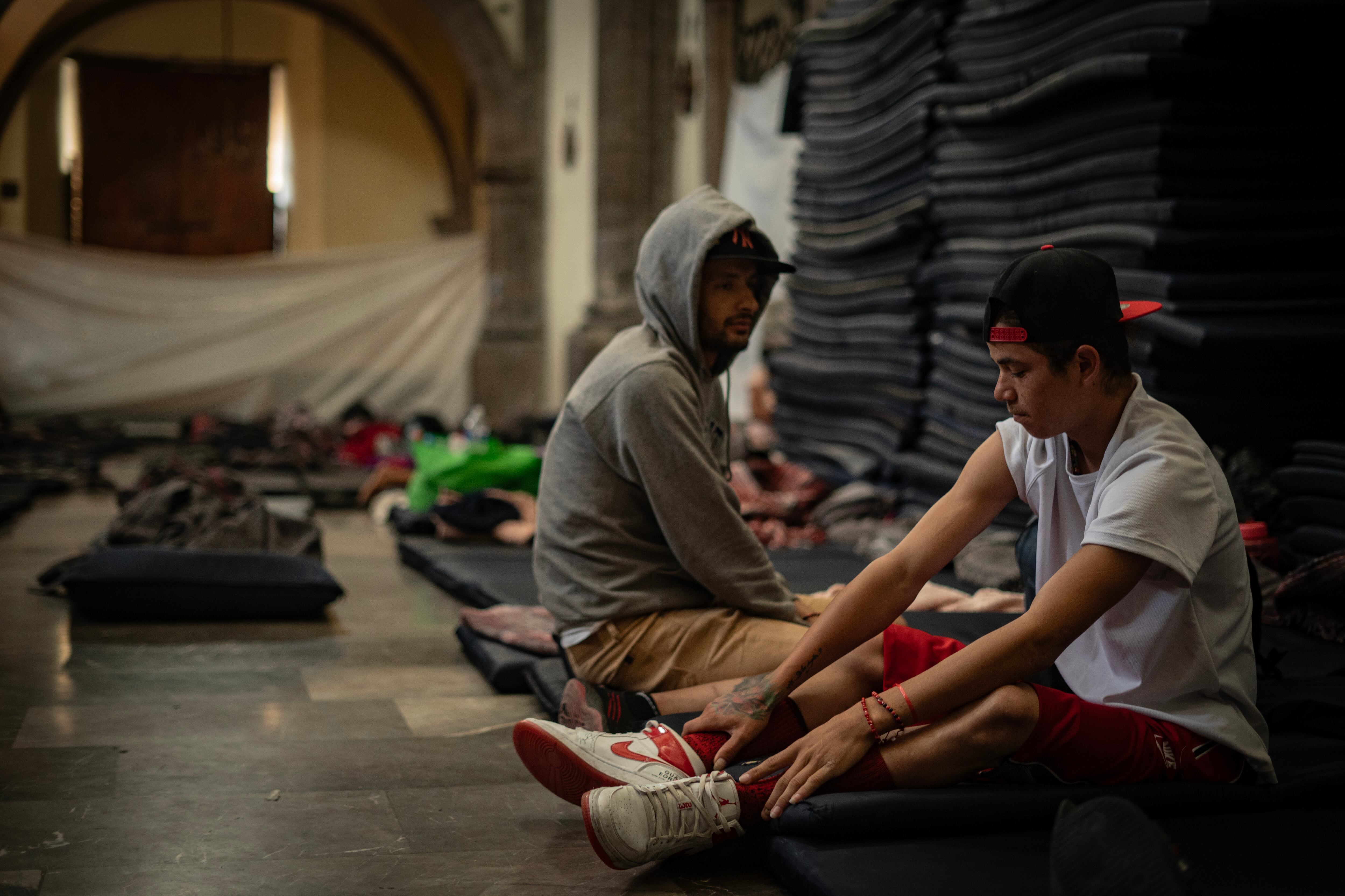 Jason Oliveros y Wilber Giovanni, migrantes venezolanos, descansan sobre colchonetas en La Soledad. 