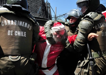 Carabineros de la Policía de Chile detienen a un manifestante vestido de Papá Noel, el 22 de diciembre, durante una protesta estudiantil en Santiago llamada "La Última del Año".