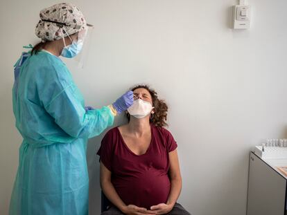 Personal medico del hospital Clinico San Carlos realizando una prueba pcr para detectar el Covid-19 a una mujer embarazada