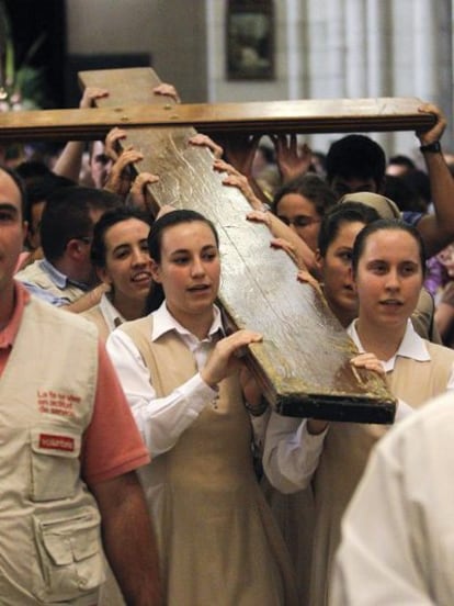 Un grupo de jóvenes porta la cruz de la juventud a su llegada a la catedral de la Almudena.