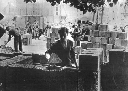 Un joven berlinés coloca ladrillos durante la edificación del muro de Berlín. La construcción inicial fue mejorada, y el muro que se erigió en 1975 era ya de hormigón armado.