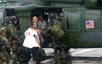 Varios periodistas y miembros de ONG embarcan en un helicóptero estadounidense para salir de la capital liberiana.