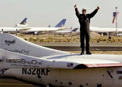 El piloto Mike Melvill celebra subido en la nave el éxito del viaje espacial al aterrizar en el desierto de Mojave.