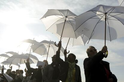 Mujeres levantando paraguas blancos en los actos del Día Internacional de la Mujer en Bruselas.