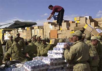 Militares iraníes distribuyen en el aeropuerto de Kermán el material que llega de todas partes para ayudar a Bam.