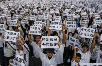 Centenares de personas sostienen carteles en los que se lee "Matrimonio y familia, dejad decidir a todo el mundo" durante una manifestación de grupos profamilia para protestar contra la legalización de matrimonios de personas del mismo sexo, en Taipei (Taiwán).