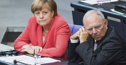 El ministro de Finanzas alem&aacute;n, Wolfgang Sch&auml;uble (d), y la canciller alemana, Angela Merkel, durante una sesi&oacute;n extraordinaria del Bundestag en la que se vot&oacute; el viernes la autorizaci&oacute;n a su Gobierno para la apertura de las negociaciones destinadas a acordar un tercer paquete de rescate para Grecia. / EFE