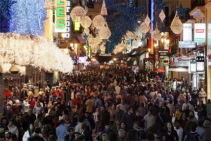 Miles de personas hacen sus compras navideñas en la calle de Preciados, una de las vías comerciales más transitadas de la capital.