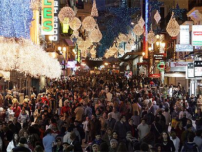 Miles de personas hacen sus compras navideñas en la calle de Preciados, una de las vías comerciales más transitadas de la capital.