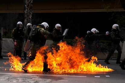 Las llamas de los 'cócteles molotov' lanzados por los manifestantes rodean a un grupo de agentes de la policía antidisturbios, durante la huelga general en Atenas este jueves.  