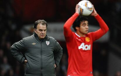 Marcelo Bielsa detrás del jugador del Manchester Rafael, en Old Trafford. 