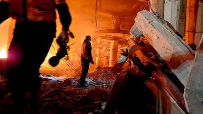 Personal de emergencias permanece entre los escombros de un edificio bombardeado por Israel, este lunes en Rafah. 