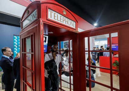 Un hombre posa para una foto en la cabina de telfonos instalada en el pabelln del Reino Unido de la COP29, que se celebra en Bak (Azerbaiyn).