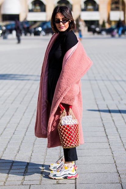 Esta foto resume a la perfección las tendencias que dominan el street style parisino: microgafas de sol, abrigo gigante y ligeramente caído, bolso con red de Staud y las zapatillas de Balenciaga.