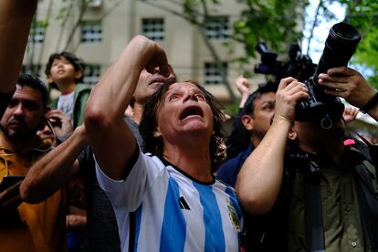 Fanáticos de Javier Milei insultan a una mujer que se manifiesta contra el candidato de ultraderecha desde un balcón, este domingo en Buenos Aires.