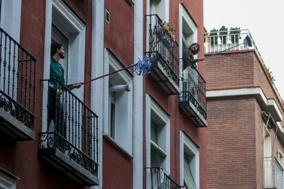 'Fregonada de Lavapiés', gesto que realizan los vecinos agitando fregonas desde sus balcones para "limpiar el virus"