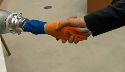 Un hombre da la mano a un robot en la Global Robot Expo de Madrid.