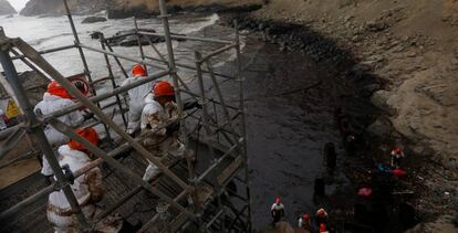 Trabajadores durante la limpieza del derrame de petróleo en la Playa Cavero, en Perú.