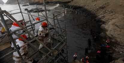 Trabajadores durante la limpieza del derrame de petróleo en la Playa Cavero, en Perú. 