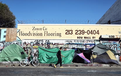 A person walks past a homeless encampment on June 28 in Los Angeles.