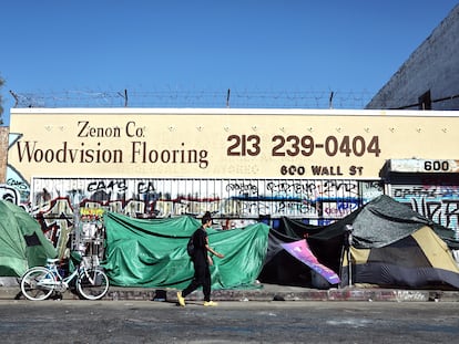 Una persona pasa frente a un campamento de personas sin hogar, el 28 de junio en Los Ángeles.