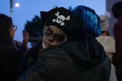 Un niño maquillado como Catrín y con un sombrero de pirata, duerme sobre el hombro de su madre, durante la Megaprocesión de este domingo.